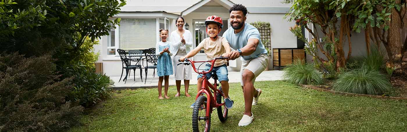 dad helping son ride a bike